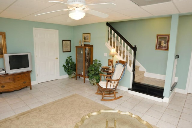 tiled foyer entrance with a paneled ceiling and ceiling fan