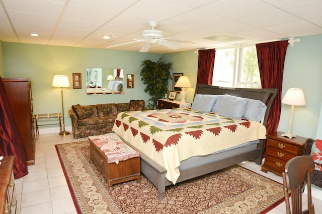 bedroom featuring a drop ceiling, ceiling fan, and light tile patterned flooring