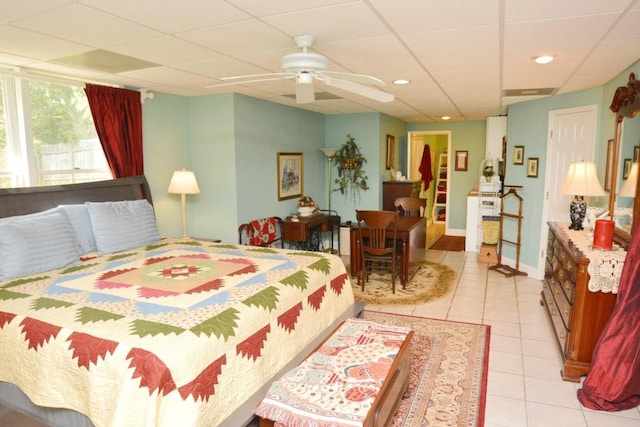 bedroom featuring a paneled ceiling, ceiling fan, and light tile patterned floors