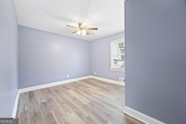 unfurnished room with ceiling fan, a textured ceiling, and light hardwood / wood-style flooring