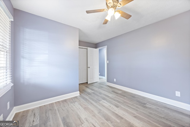 unfurnished bedroom with ceiling fan, light hardwood / wood-style floors, and a closet