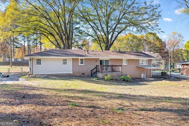 rear view of property with a lawn and a deck