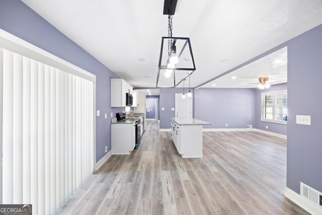 kitchen with white cabinets, ceiling fan, pendant lighting, and appliances with stainless steel finishes