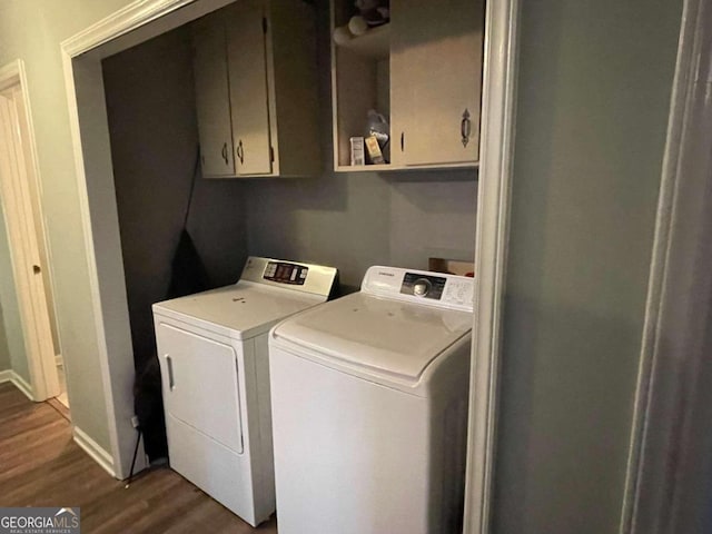 clothes washing area with dark hardwood / wood-style floors, cabinets, and separate washer and dryer