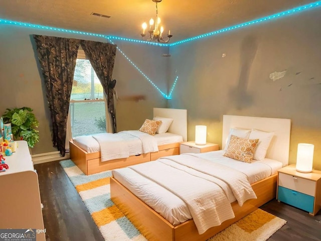 bedroom featuring dark wood-type flooring and a notable chandelier