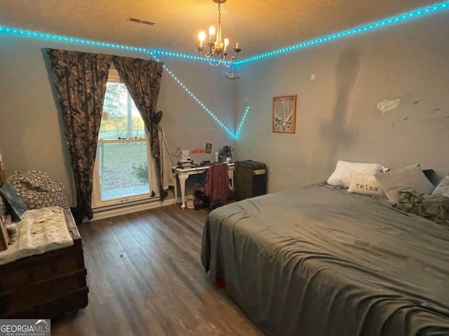 bedroom with dark hardwood / wood-style floors and a chandelier