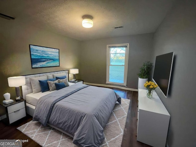 bedroom featuring hardwood / wood-style floors and a textured ceiling