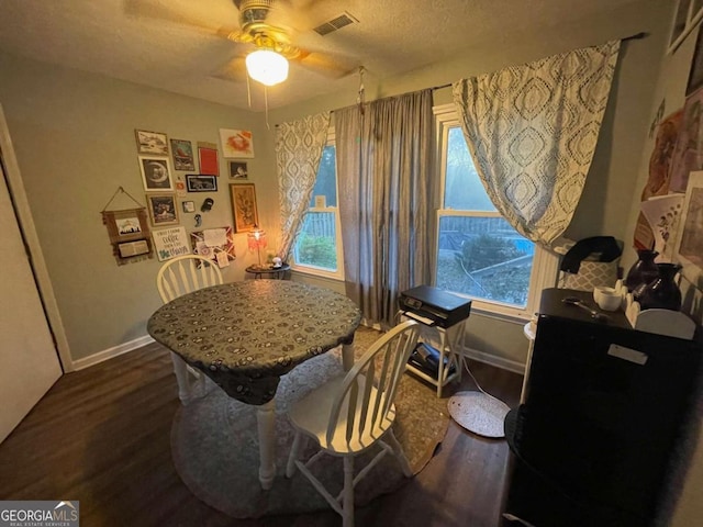 dining area featuring a wealth of natural light, dark hardwood / wood-style flooring, ceiling fan, and a textured ceiling