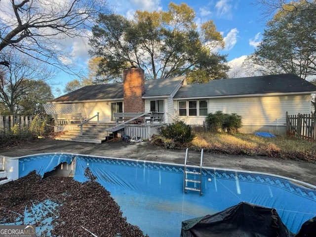 rear view of house with a pool side deck