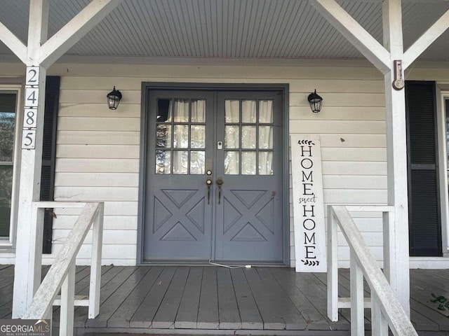 doorway to property featuring covered porch and french doors