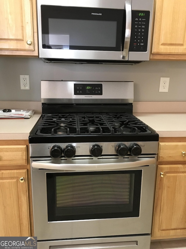 kitchen with light brown cabinetry and stainless steel appliances