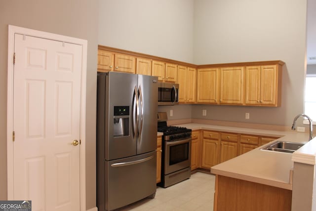 kitchen featuring sink, light brown cabinets, appliances with stainless steel finishes, and kitchen peninsula