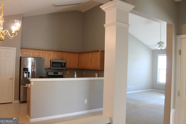 kitchen featuring appliances with stainless steel finishes, decorative columns, decorative light fixtures, light colored carpet, and ceiling fan with notable chandelier