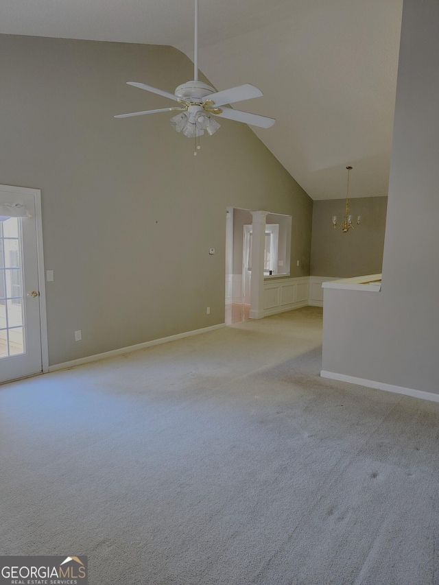 unfurnished room with ceiling fan with notable chandelier, light colored carpet, and high vaulted ceiling