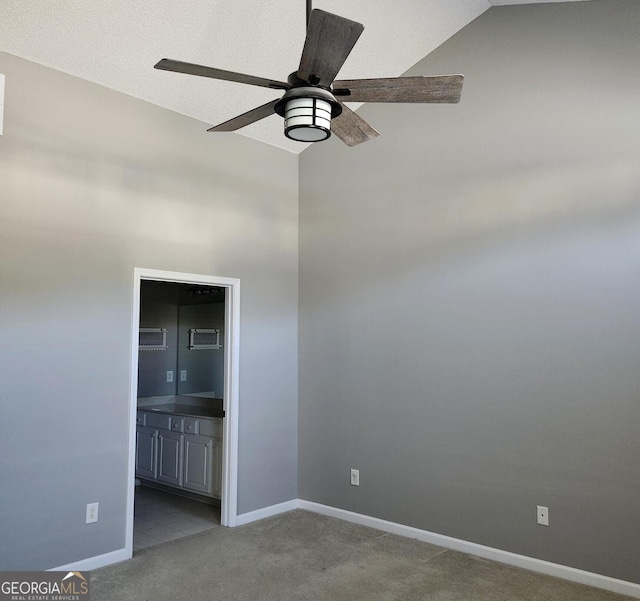 carpeted empty room with ceiling fan and lofted ceiling