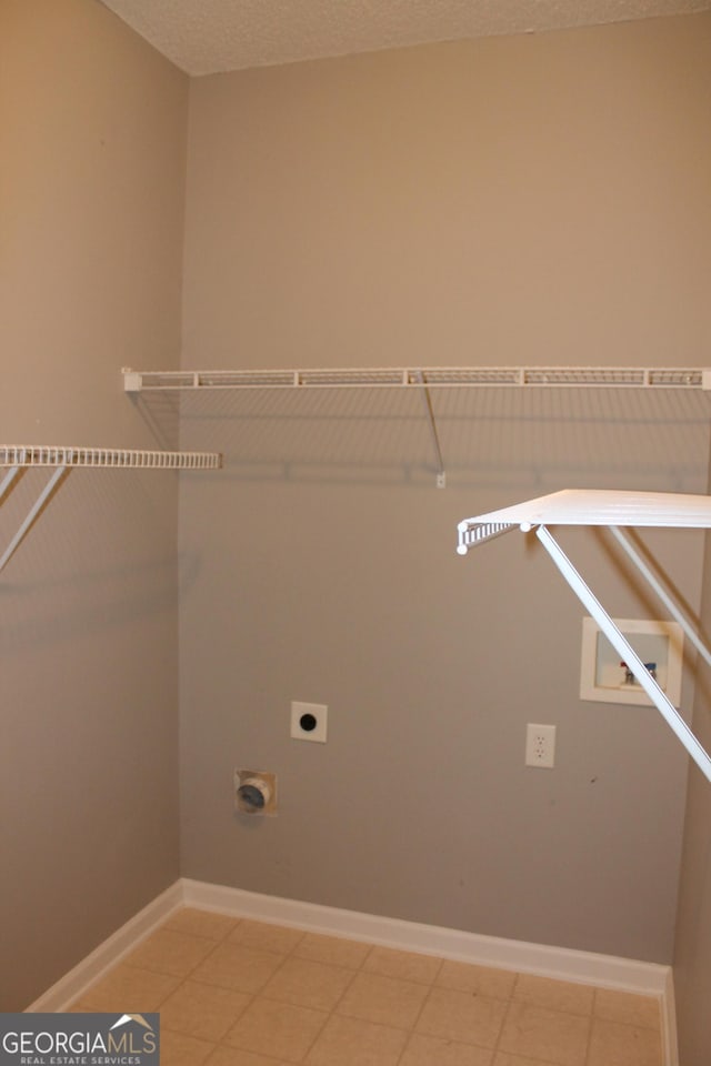 washroom with electric dryer hookup and a textured ceiling