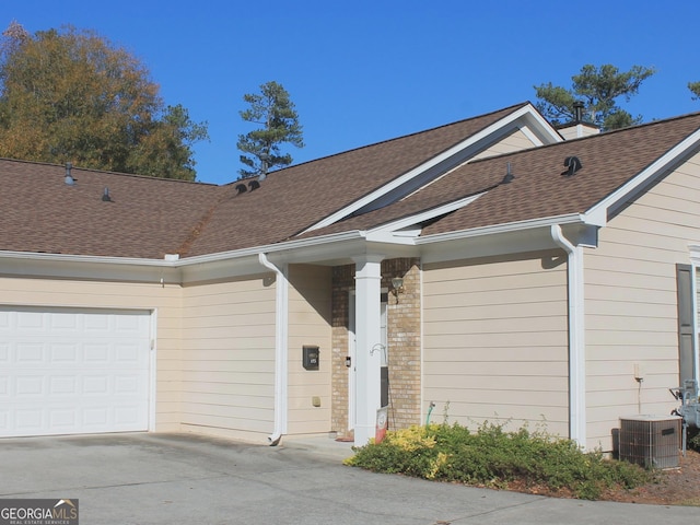 view of front of home featuring a garage and central AC unit