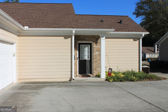 view of exterior entry featuring central air condition unit and a garage