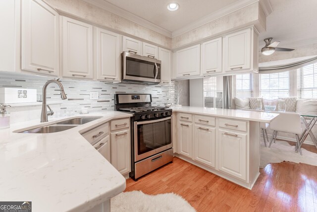111 Swanton Hill Ct, Decatur, GA 30030 - kitchen with ornamental molding, a sink, appliances with stainless steel finishes, a peninsula, and white cabinets