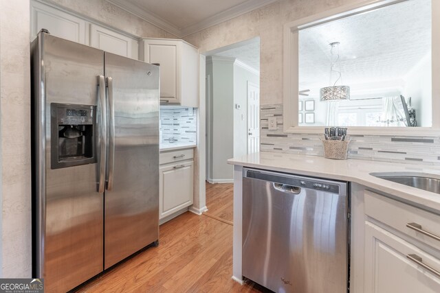 111 Swanton Hill Ct, Decatur, GA 30030 - kitchen with light wood-type flooring, light countertops, ornamental molding, white cabinets, and stainless steel appliances