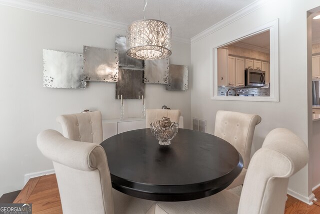 111 Swanton Hill Ct, Decatur, GA 30030 - dining space featuring wood finished floors, baseboards, visible vents, ornamental molding, and a chandelier