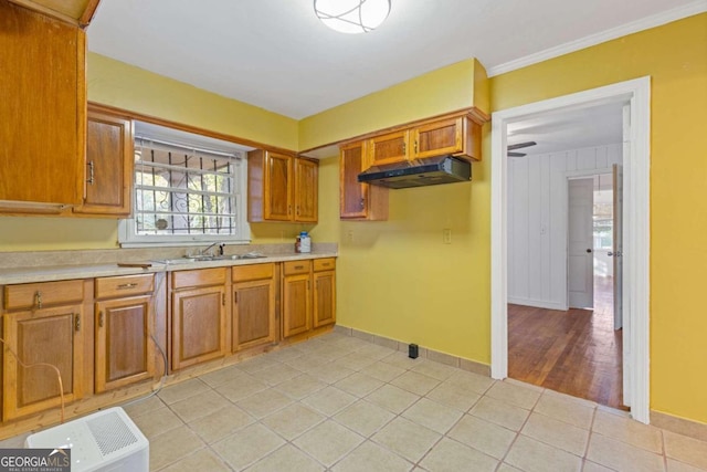 kitchen featuring sink, light tile patterned floors, and ornamental molding