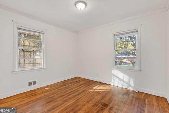 unfurnished room with hardwood / wood-style flooring, a healthy amount of sunlight, and crown molding