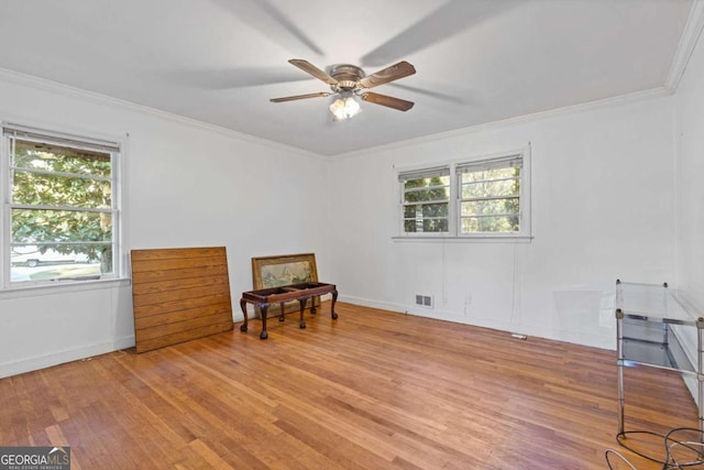 sitting room with light hardwood / wood-style flooring, a wealth of natural light, ornamental molding, and ceiling fan