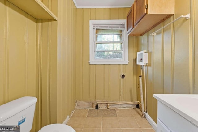 interior space with toilet, wood walls, tile patterned flooring, and ornamental molding