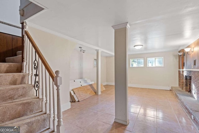 basement with light tile patterned floors, a brick fireplace, and crown molding