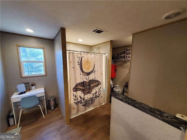 bathroom with a shower with curtain, a textured ceiling, and hardwood / wood-style flooring