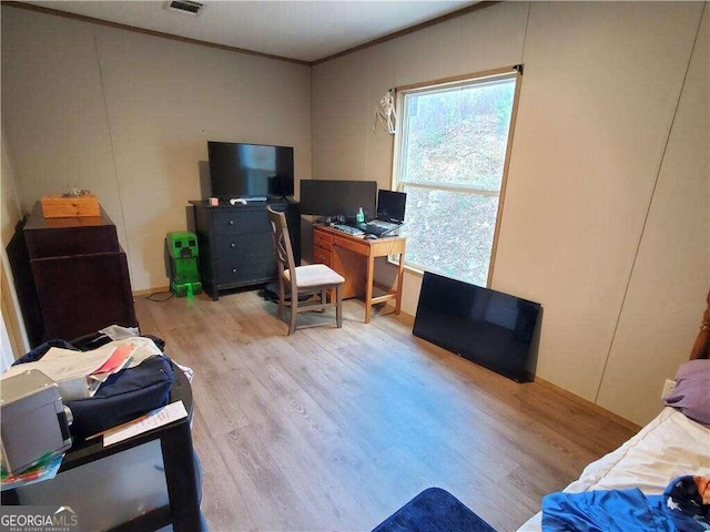 office space with light hardwood / wood-style floors and ornamental molding