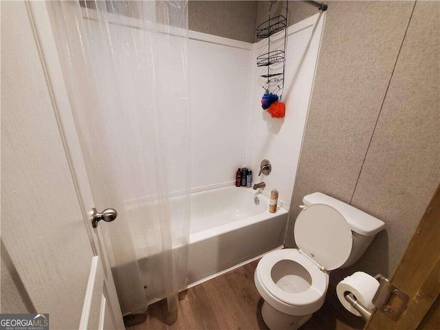 bathroom with toilet, tub / shower combination, and hardwood / wood-style flooring