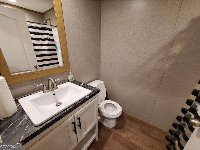 bathroom with hardwood / wood-style floors, vanity, and toilet