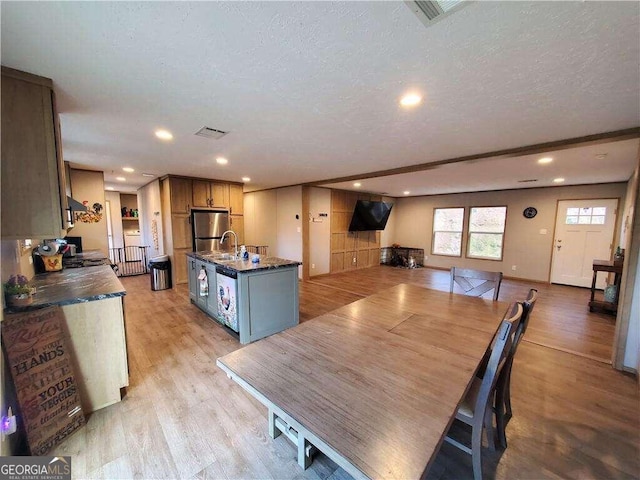 dining area with light hardwood / wood-style flooring, a textured ceiling, and sink