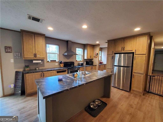 kitchen featuring wall chimney range hood, a textured ceiling, light hardwood / wood-style floors, and black appliances