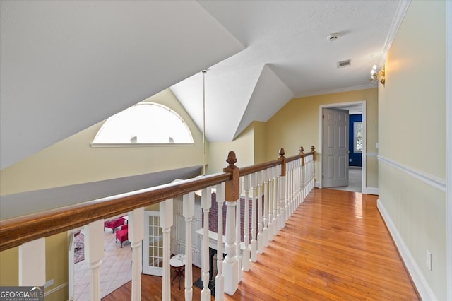 hall featuring hardwood / wood-style flooring, crown molding, and lofted ceiling