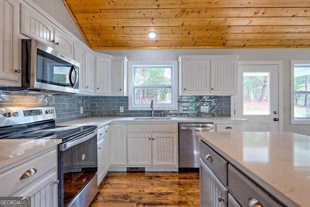 kitchen featuring white cabinets, sink, vaulted ceiling, appliances with stainless steel finishes, and wood ceiling