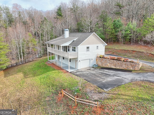 view of home's exterior featuring a garage, a yard, a balcony, and central air condition unit