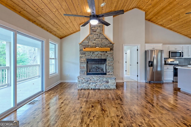 unfurnished living room featuring a stone fireplace, high vaulted ceiling, wood ceiling, and wood-type flooring