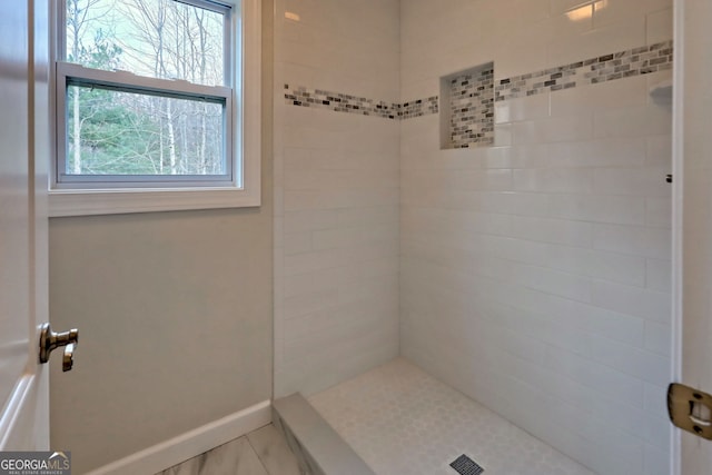 bathroom featuring a tile shower