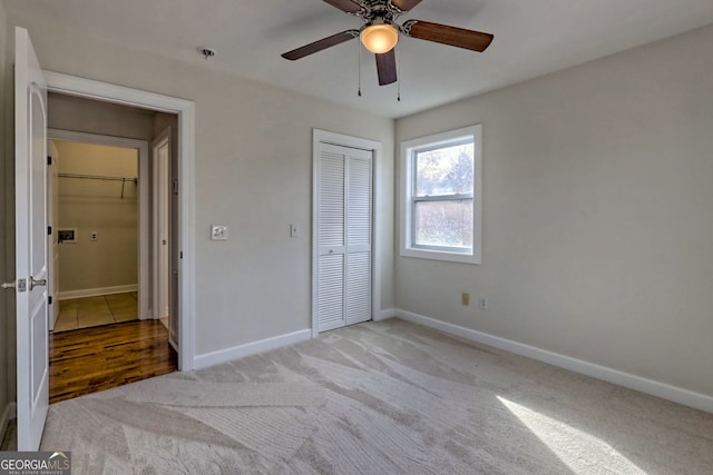 unfurnished bedroom featuring light carpet, a closet, and ceiling fan