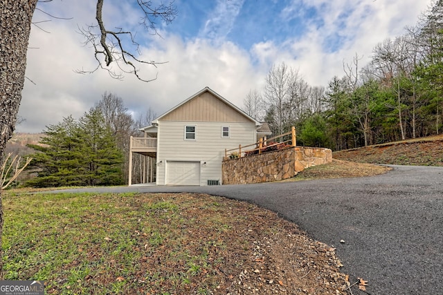 view of property exterior featuring a garage and a wooden deck