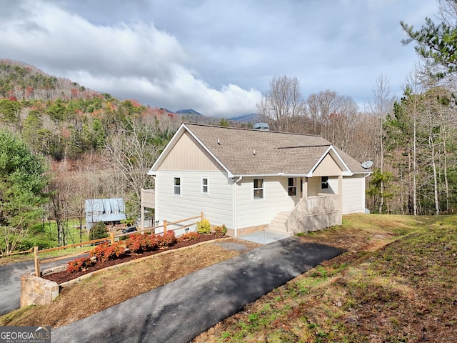 4502 Ramsay Dr, Hiawassee, GA 30546 - view of side of home featuring covered porch, roof with shingles, a mountain view, and a wooded view