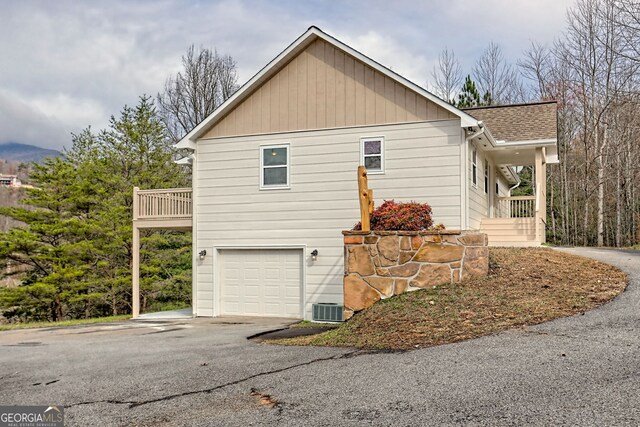 view of property exterior with a balcony, a garage, and central air condition unit