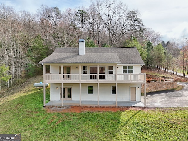 rear view of property featuring a lawn, a patio, and french doors