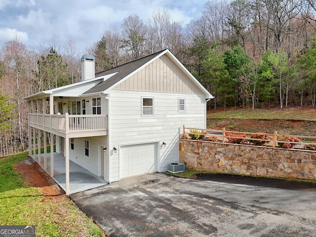 4502 Ramsay Dr, Hiawassee, GA 30546 - view of property exterior with driveway, a balcony, a chimney, board and batten siding, and central AC