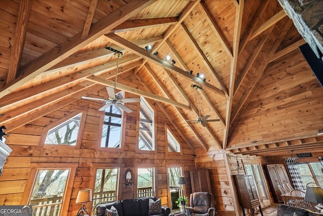 unfurnished living room featuring a ceiling fan, wooden ceiling, wood walls, and beam ceiling