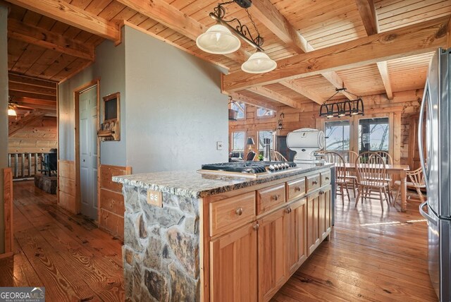 details with beam ceiling, a wood stove, hardwood / wood-style floors, and wood ceiling