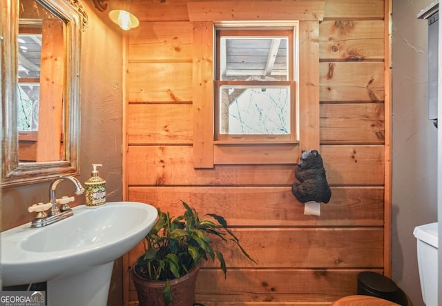 half bath featuring toilet and a sink